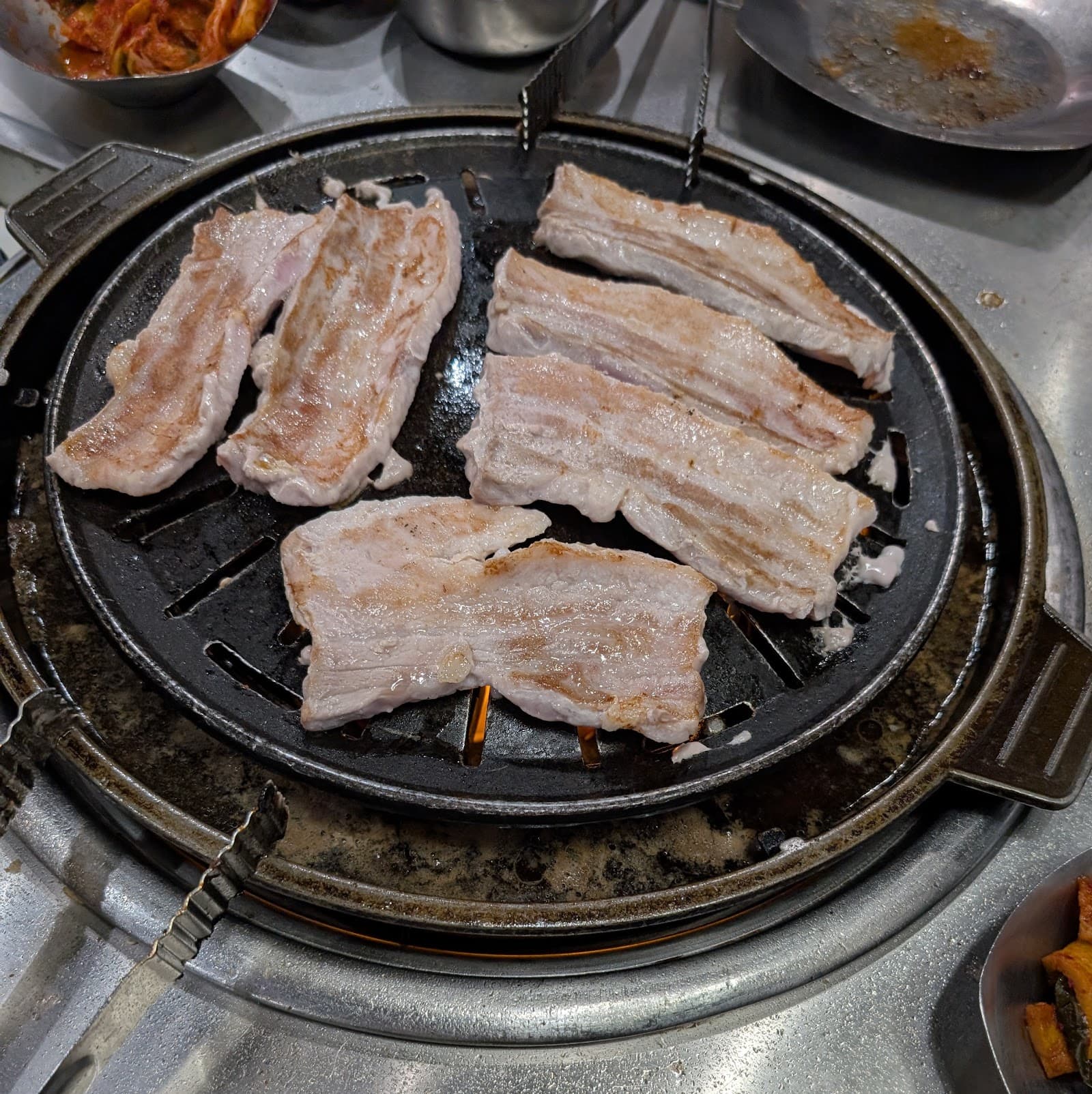 Table full of Korean BBQ meats and banchan side dishes at Kogiya